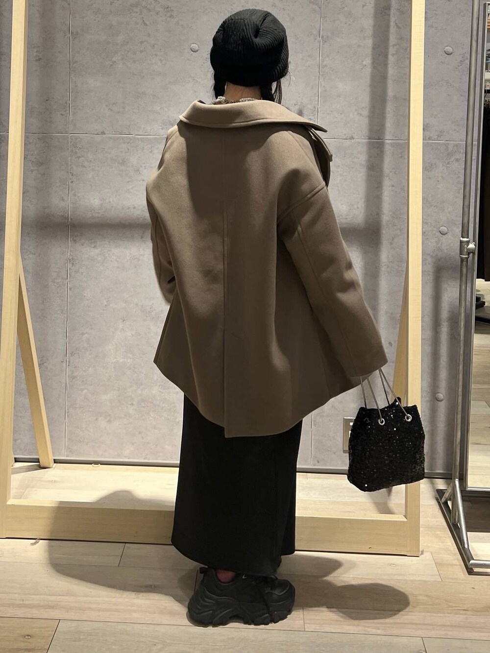 ホワイト系のTシャツ/カットソー、ブラック系のスカート、ブラウン系のその他アウターを着用したレディースの秋コーディネートの4枚目の写真