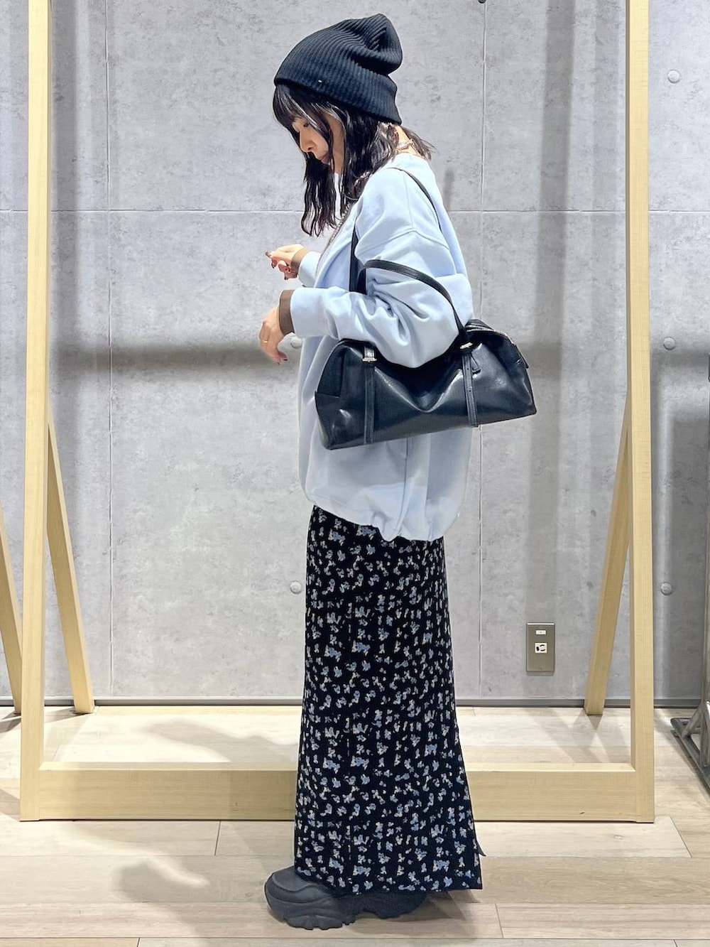 ブラック系のボストンバッグ、ブラック系のスカート、ブルー系のTシャツ/カットソーを着用したレディースの冬コーディネートの2枚目の写真