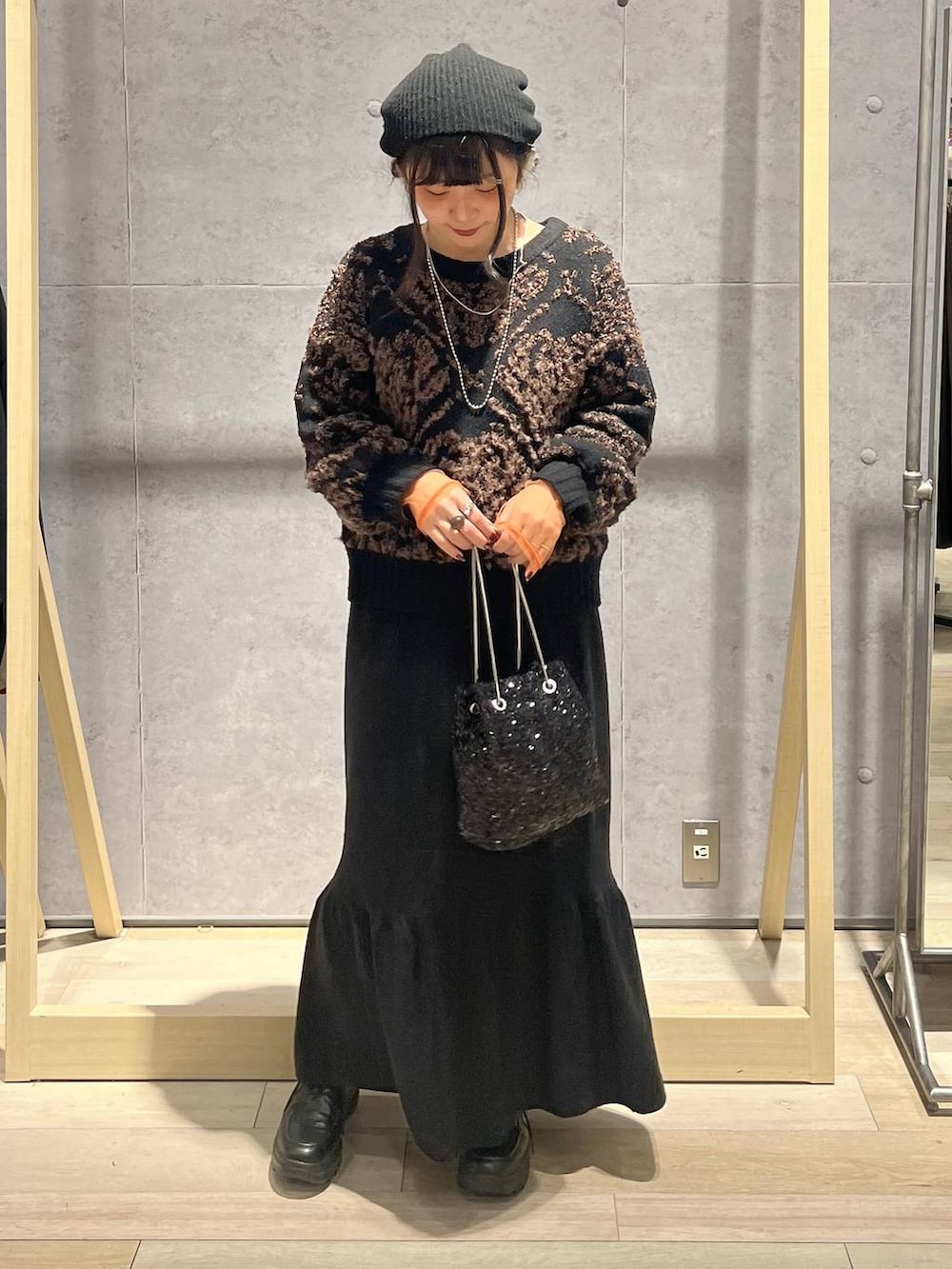 ブラック系のTシャツ/カットソー、ブラック系のスカート、ブラック系のショルダーバッグを着用したレディースの秋コーディネートの6枚目の写真