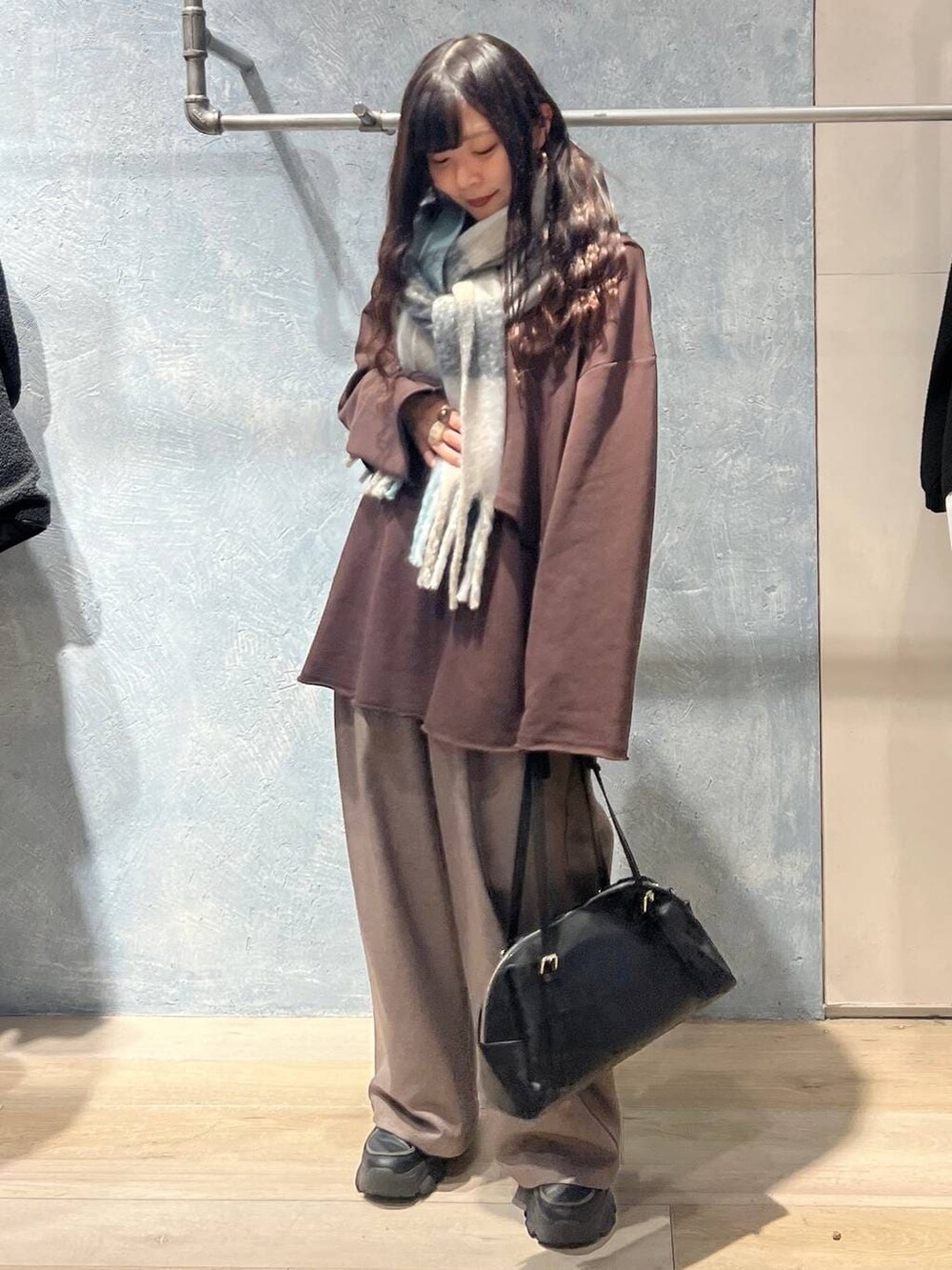 ブラック系のボストンバッグ、ブラウン系のスウェット、ブラウン系のその他パンツを着用したレディースの冬コーディネートの4枚目の写真