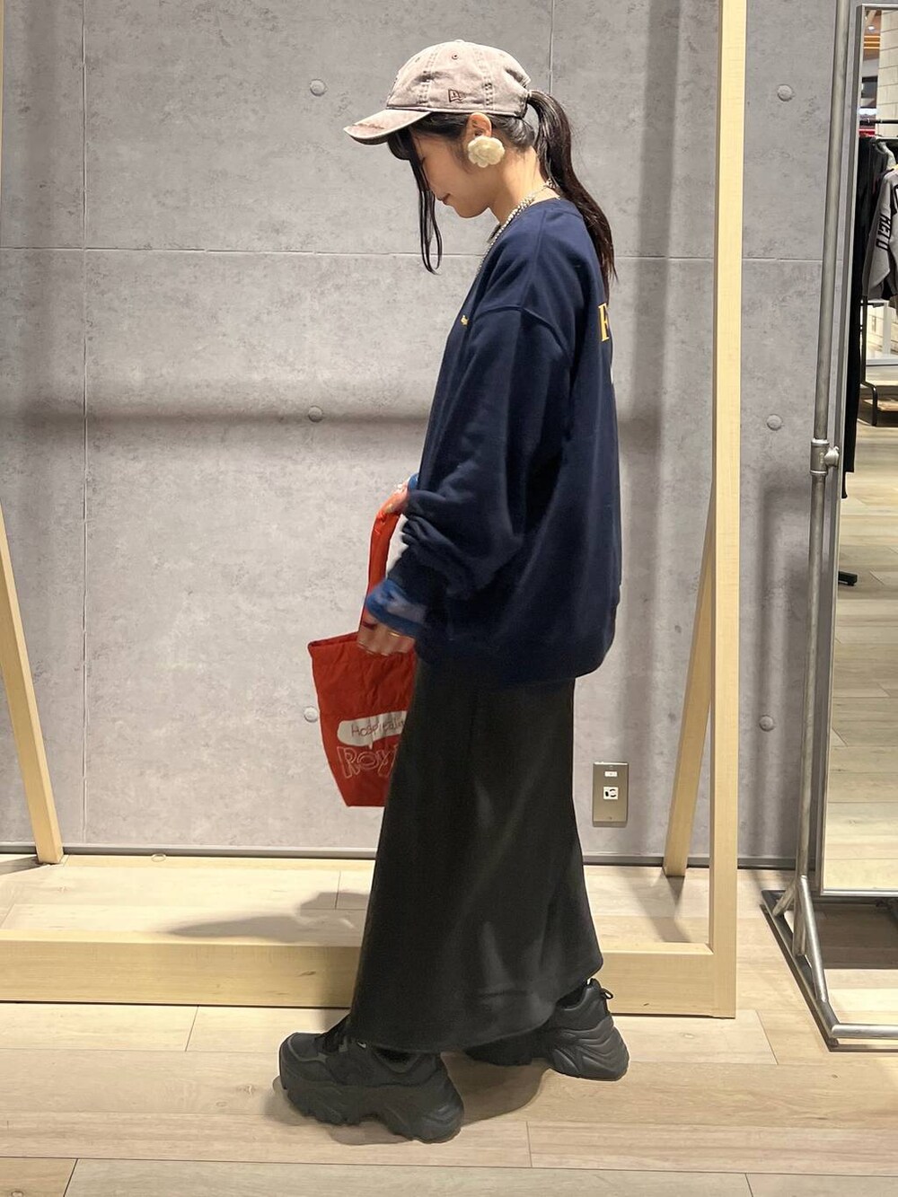 ブラック系のTシャツ/カットソー、ブラック系のスカート、ブルー系のスウェットを着用したレディースの秋コーディネートの4枚目の写真