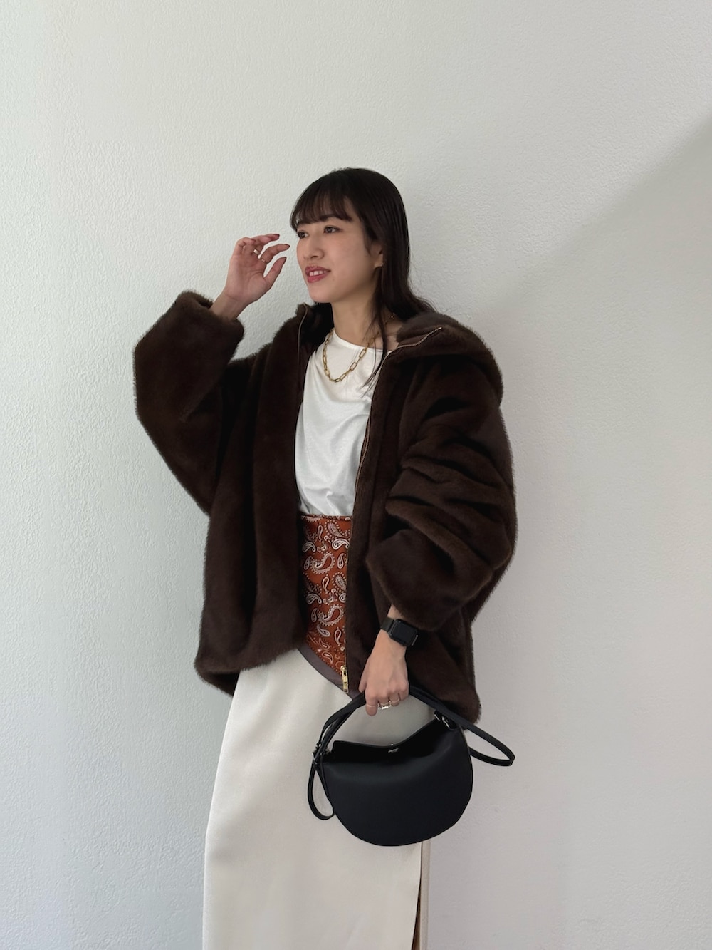 ブラウン系のブルゾン、ホワイト系のTシャツ/カットソー、ホワイト系のスカートを着用したレディースの秋コーディネートの2枚目の写真