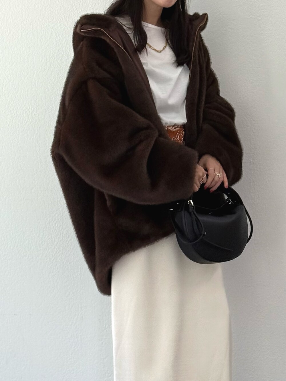 ブラウン系のブルゾン、ホワイト系のTシャツ/カットソー、ホワイト系のスカートを着用したレディースの秋コーディネートの3枚目の写真