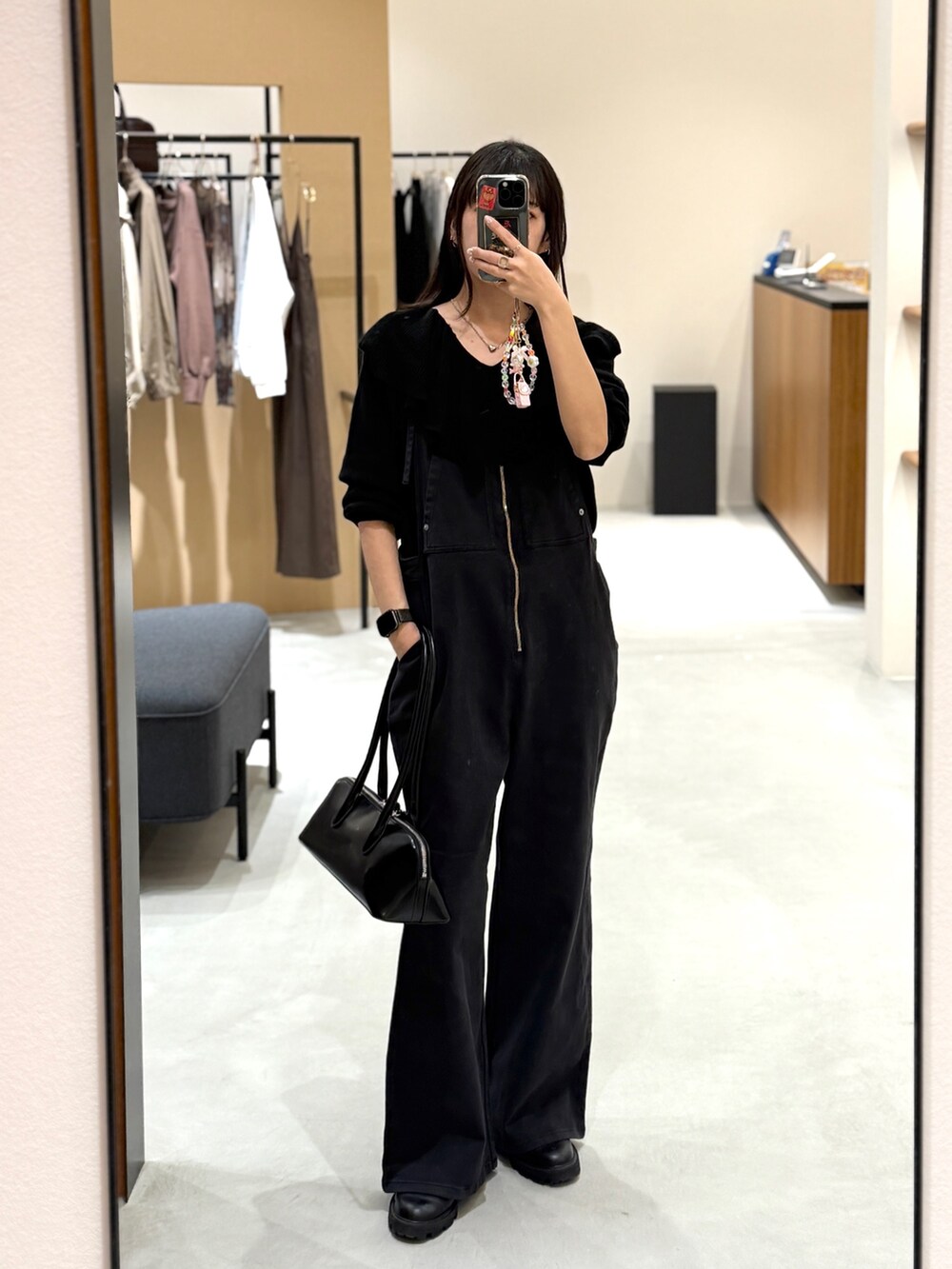 ブラック系のサロペット/オーバーオール、ブラック系のニット/セーター、ブラック系のボストンバッグを着用したレディースの秋コーディネートの2枚目の写真