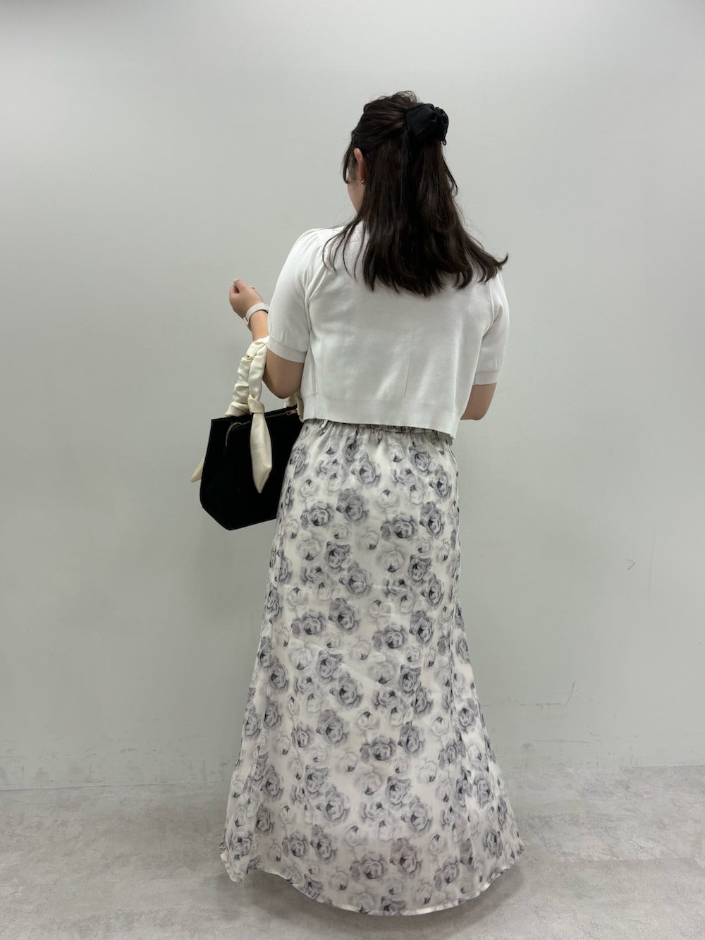 ホワイト系のワンピース、ブラック系のトートバッグ、ホワイト系のカーディガン/ボレロを着用したレディースの夏コーディネートの3枚目の写真