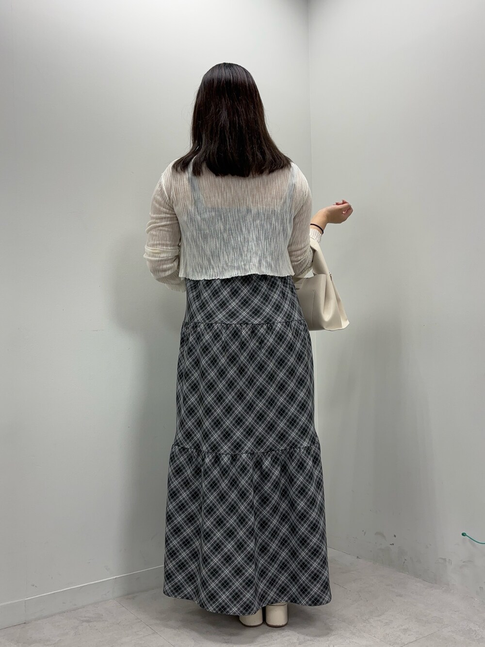 ブラック系のワンピース、ブラウン系のハンドバッグ、ホワイト系のカーディガン/ボレロを着用したレディースの夏コーディネートの3枚目の写真