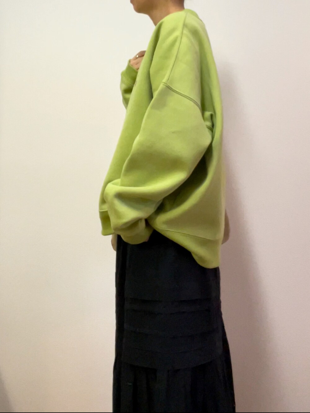 ブラック系のスカート、グリーン系のスウェットを着用したレディースの冬コーディネートの2枚目の写真