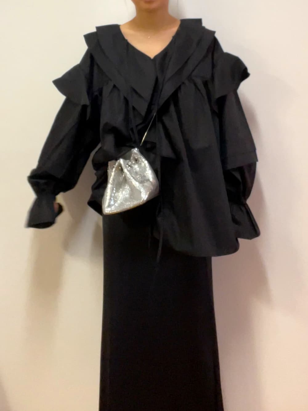 ブラック系のシャツ/ブラウス、シルバー系のショルダーバッグ、ブラック系のスカートを着用したレディースの冬コーディネートの2枚目の写真