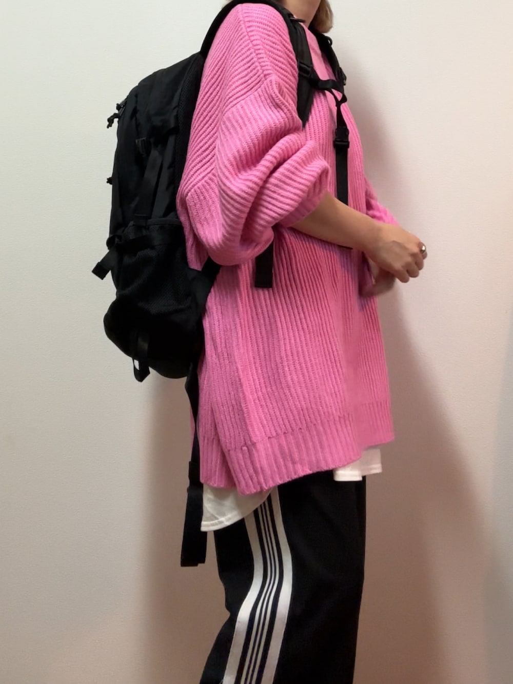 ブラック系のスウェットパンツ、ピンク系のニット/セーター、ホワイト系のタンクトップを着用したレディースの秋コーディネートの2枚目の写真