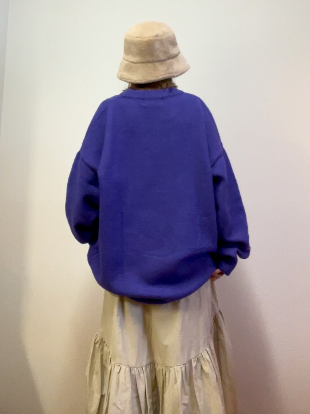 ベージュ系のスカート、パープル系のニット/セーターを着用したレディースの冬コーディネートの3枚目の写真