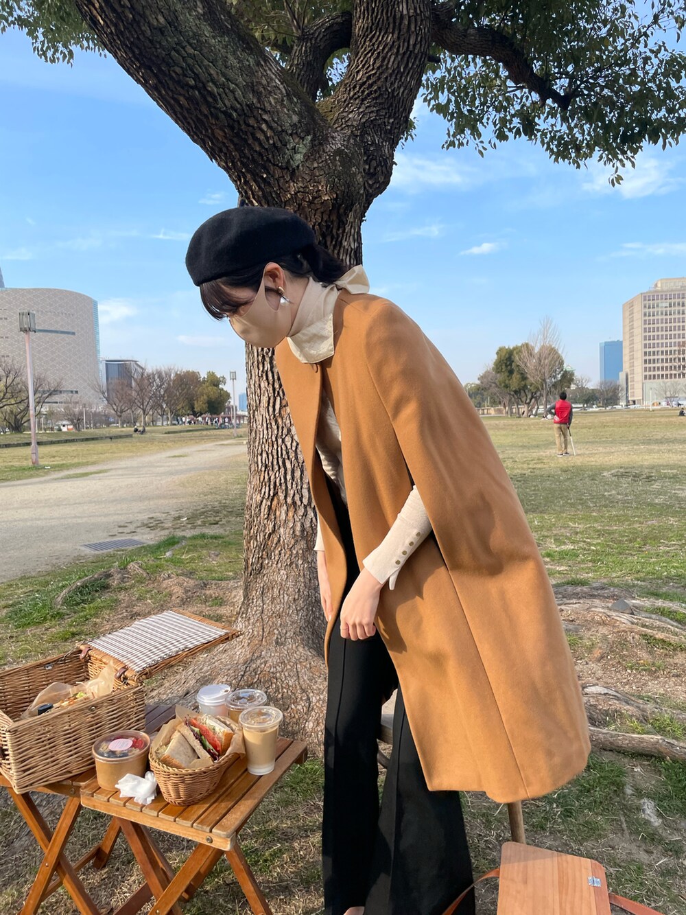 ブラウン系のポンチョ、ベージュ系のニット/セーター、ベージュ系のシャツ/ブラウスを着用したレディースの秋コーディネートの3枚目の写真