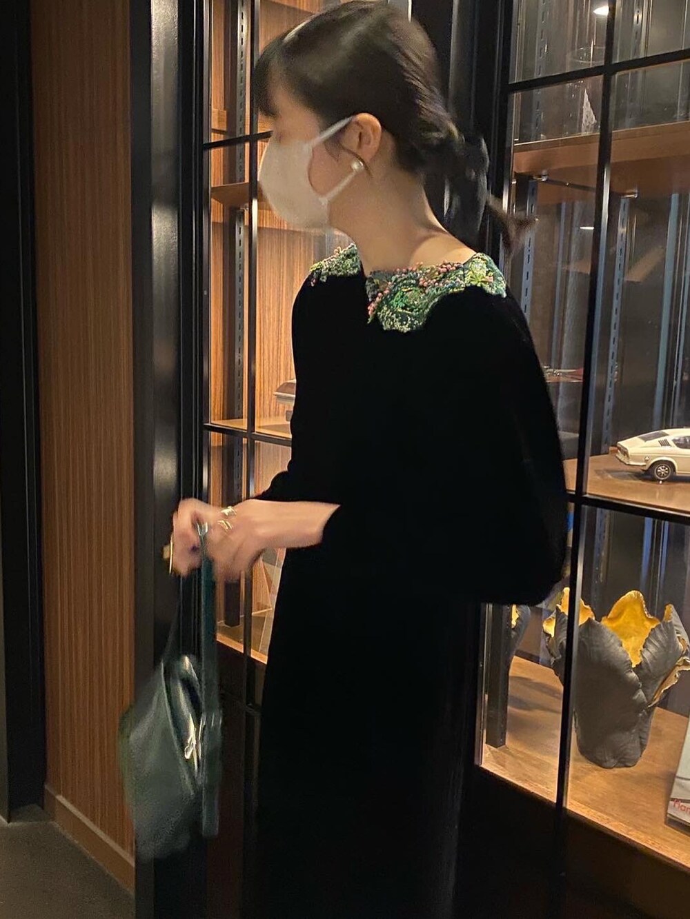 ブラック系のドレス、グリーン系のハンドバッグを着用したレディースの秋コーディネートの4枚目の写真