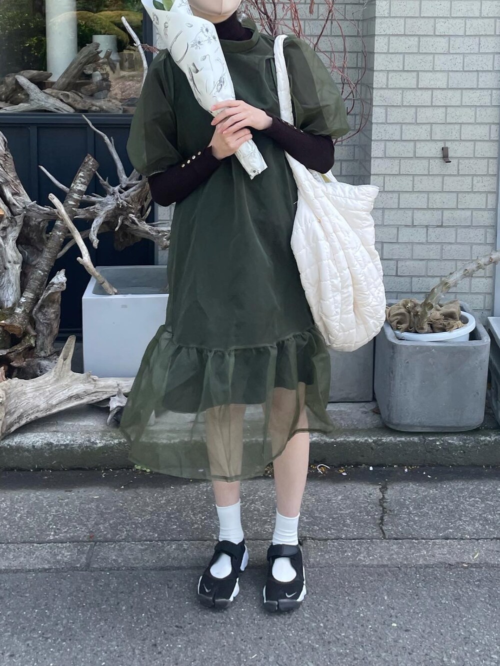 ブラック系のサンダル、グリーン系のワンピース、ブラウン系のニット/セーターを着用したレディースの春コーディネートの3枚目の写真