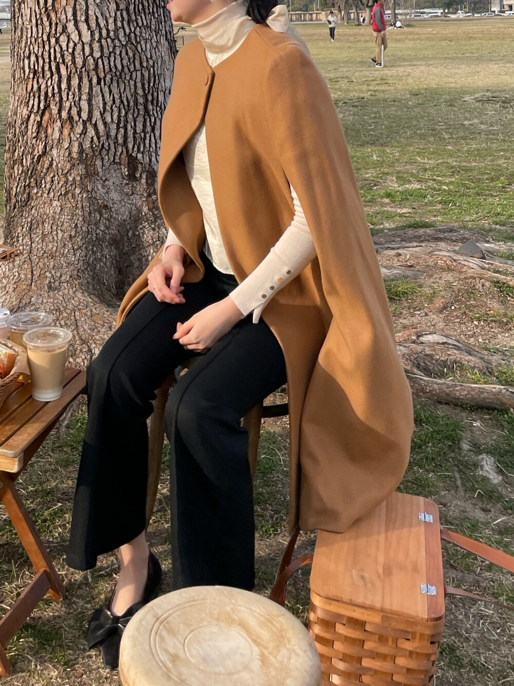 ブラウン系のポンチョ、ベージュ系のニット/セーター、ベージュ系のシャツ/ブラウスを着用したレディースの秋コーディネートの2枚目の写真