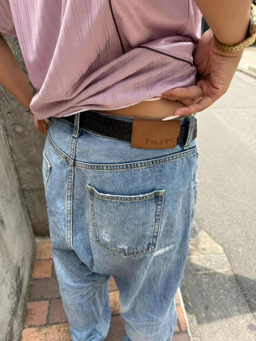 ブルー系のデニムパンツ、パープル系のTシャツ/カットソー、ブラウン系のサングラスを着用したメンズの夏コーディネートの5枚目の写真