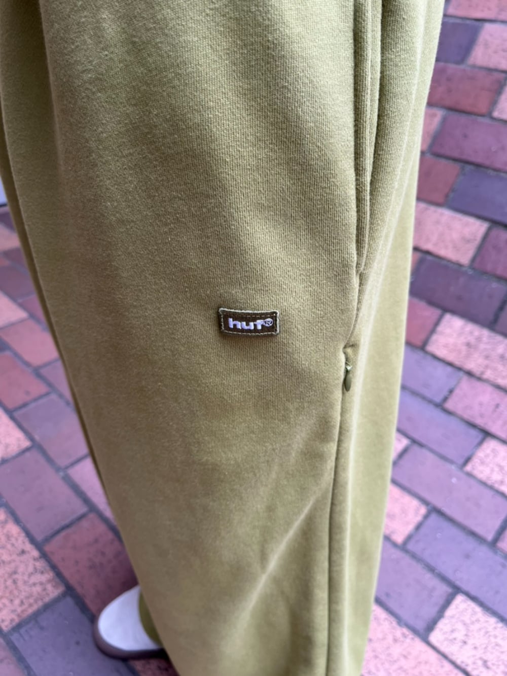 ベージュ系のTシャツ/カットソー、グリーン系のスウェットパンツを着用したメンズの夏コーディネートの3枚目の写真