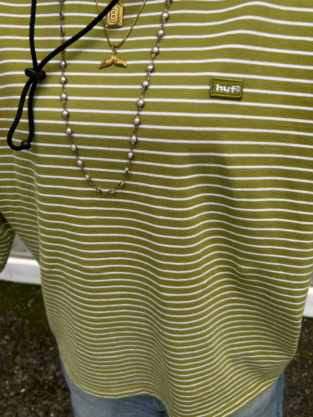 ブルー系のデニムパンツ、その他のサンダル、グリーン系のTシャツ/カットソーを着用したレディースの夏コーディネートの3枚目の写真