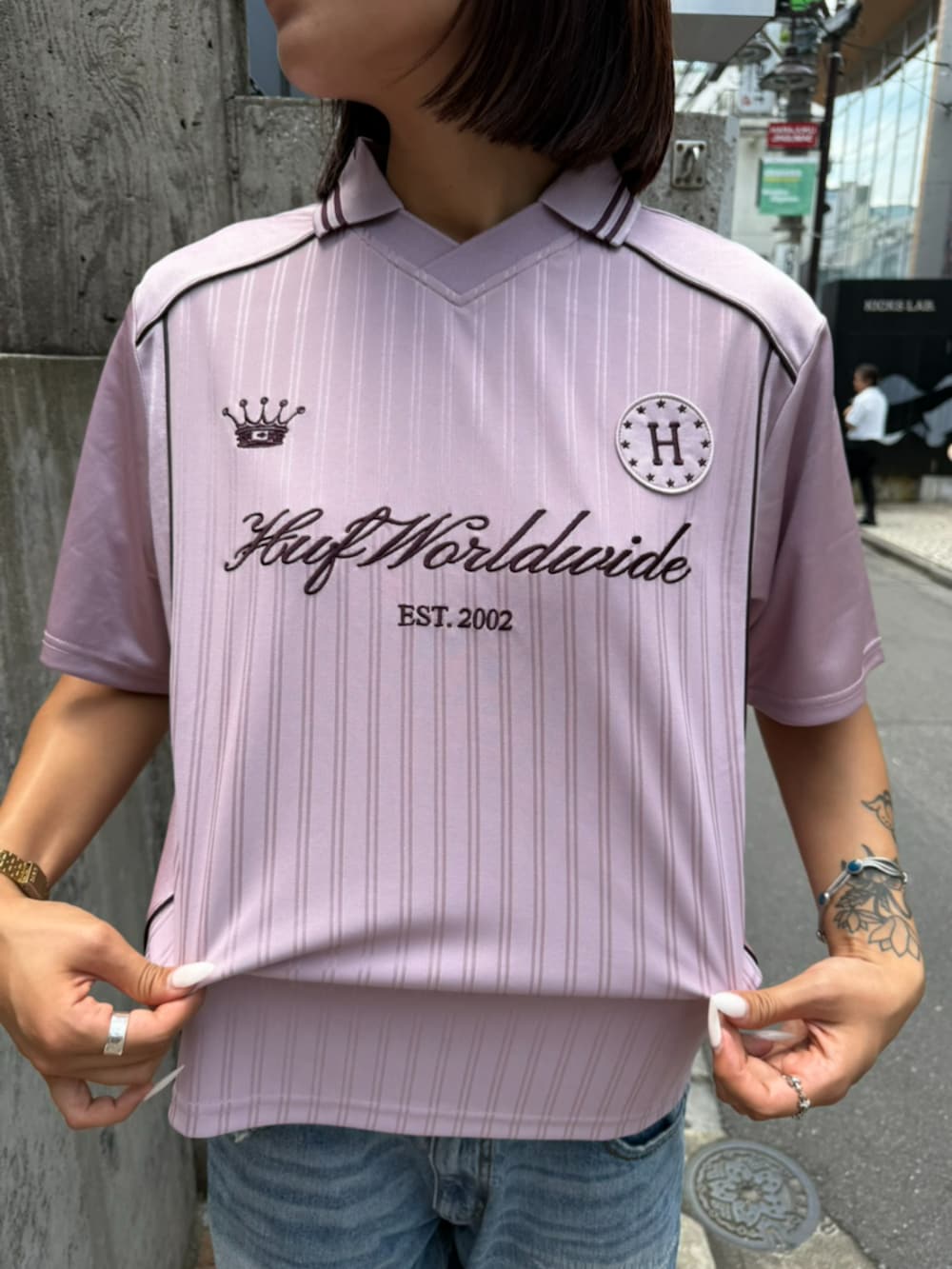 ブルー系のデニムパンツ、パープル系のTシャツ/カットソー、ブラウン系のサングラスを着用したメンズの夏コーディネートの3枚目の写真