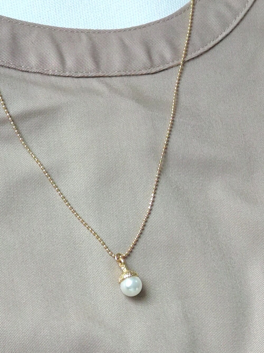 ベージュ系のワンピース、ブラウン系のショルダーバッグ、ゴールド系のネックレスを着用したレディースの秋コーディネートの4枚目の写真