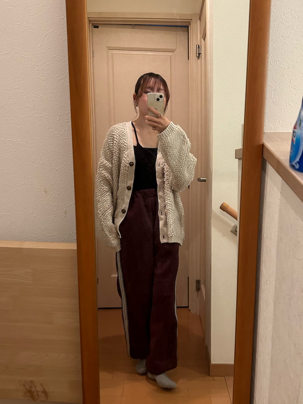 レッド系のパンツ、ホワイト系のカーディガン/ボレロを着用したレディースの秋コーディネートの2枚目の写真