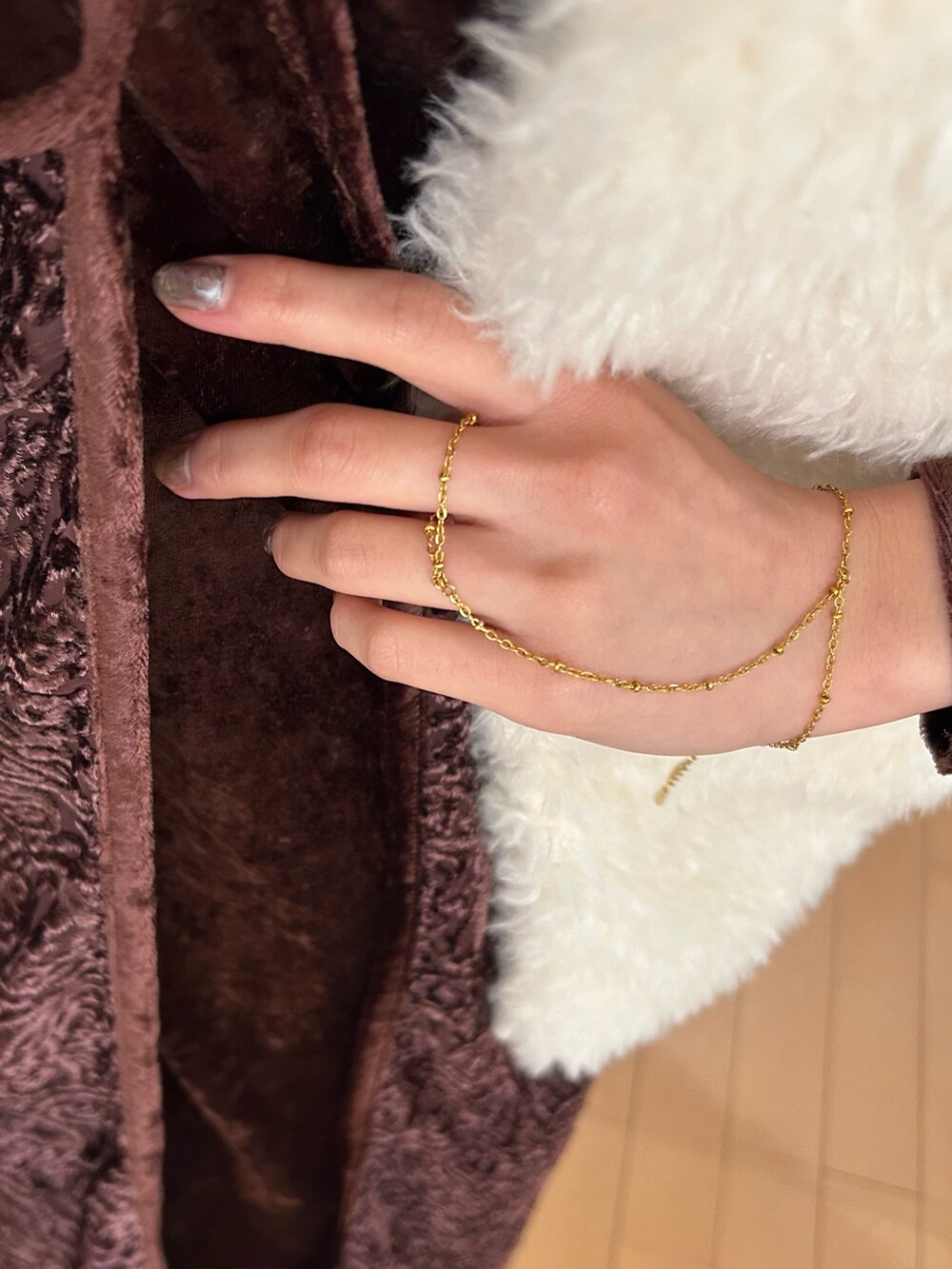 ホワイト系のベスト、ブラウン系のワンピース/ドレス、ブルー系のデニムパンツを着用したレディースの冬コーディネートの3枚目の写真