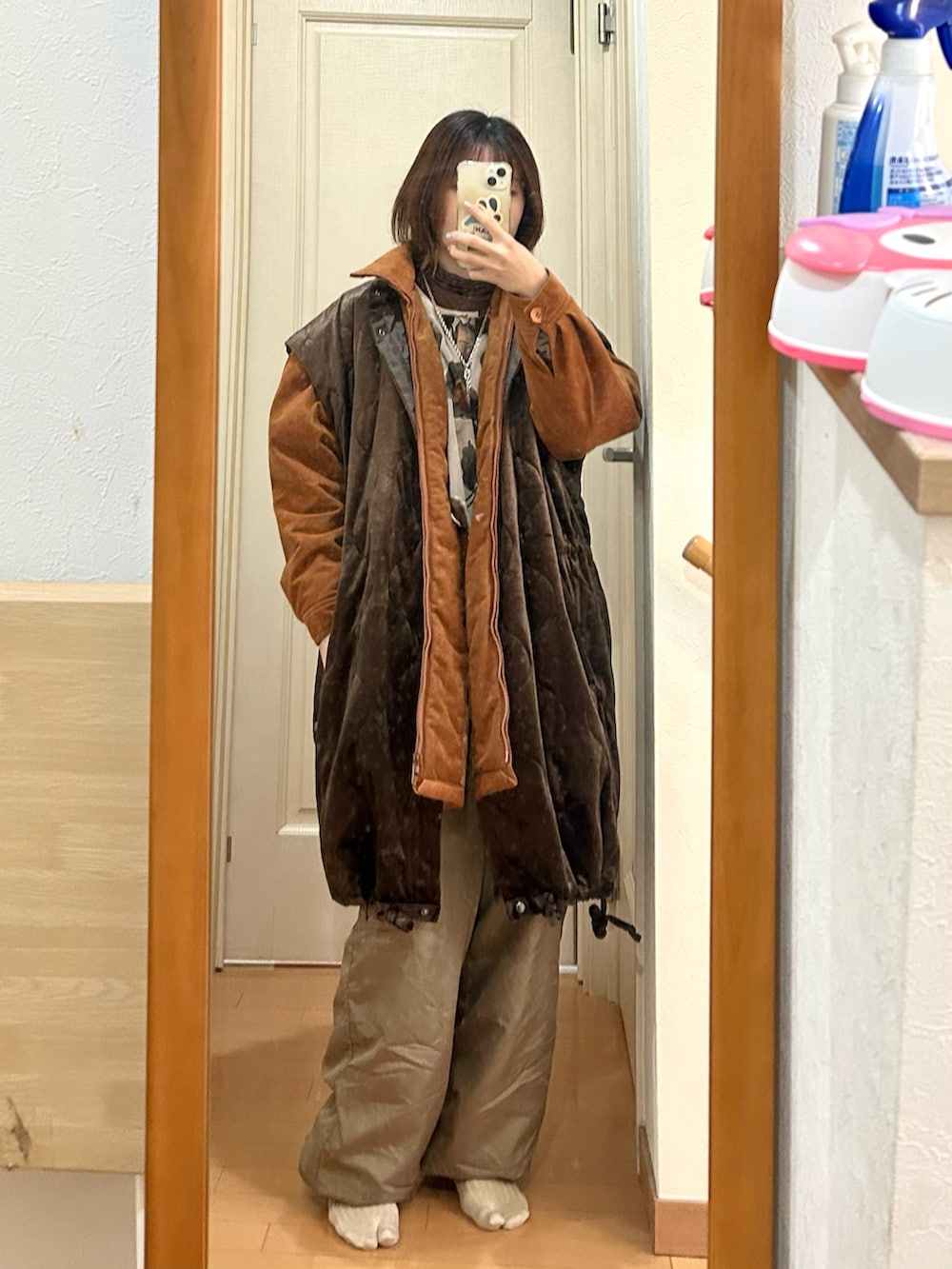 グリーン系のパンツ、ブラウン系のダウンジャケット/コート、ブラウン系のTシャツ/カットソーを着用したレディースの冬コーディネートの2枚目の写真