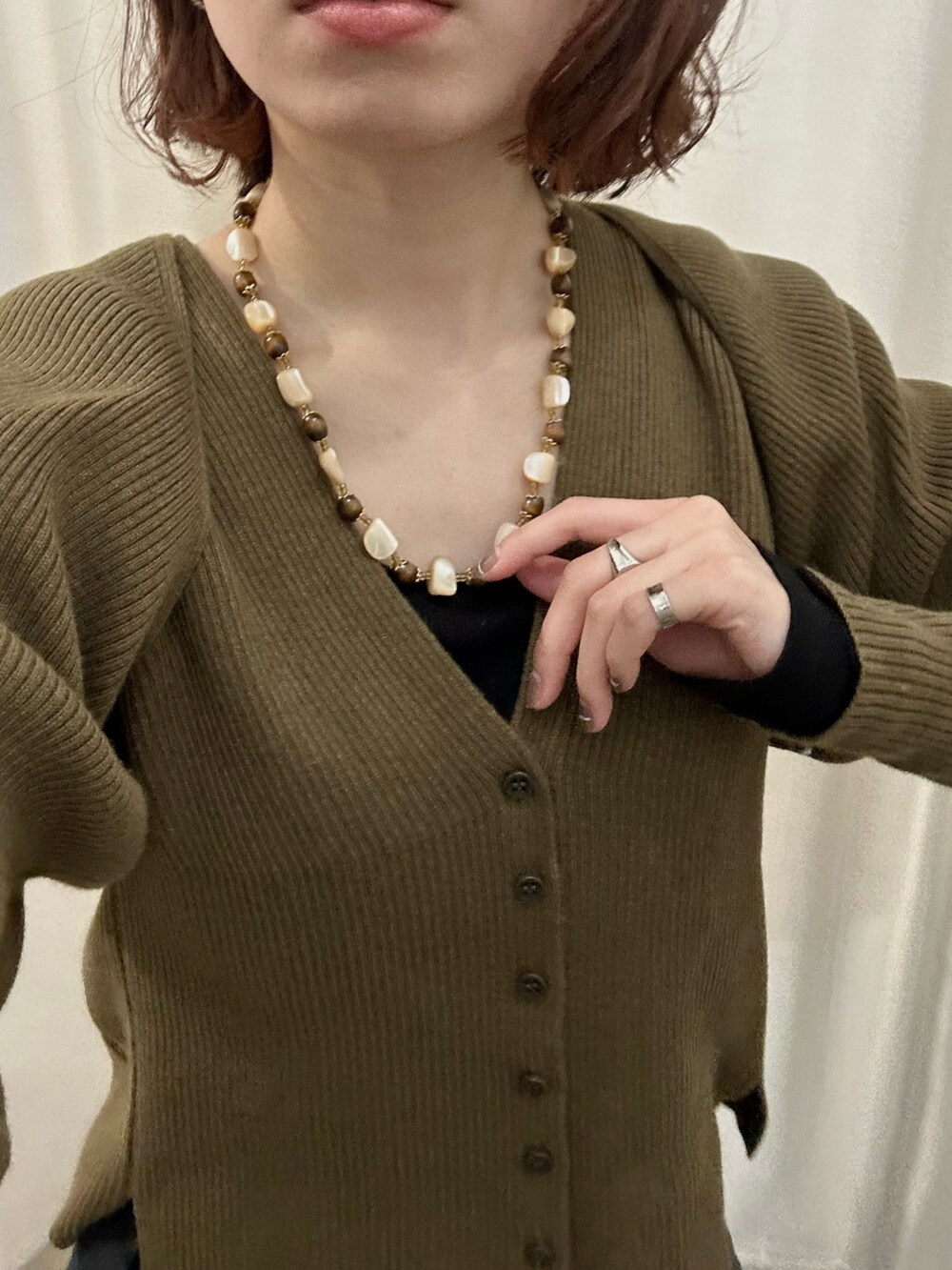 ブラック系のパンツ、ブラウン系のニット/セーターを着用したレディースの春コーディネートの2枚目の写真