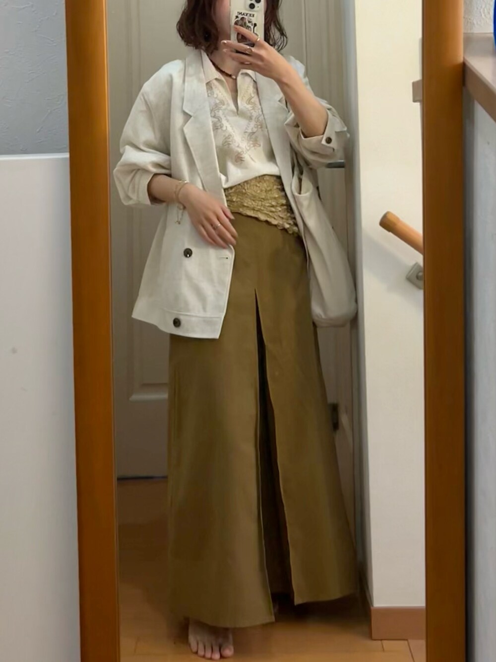 イエロー系のスカート、ホワイト系のシャツ/ブラウスを着用したレディースの春コーディネートの2枚目の写真