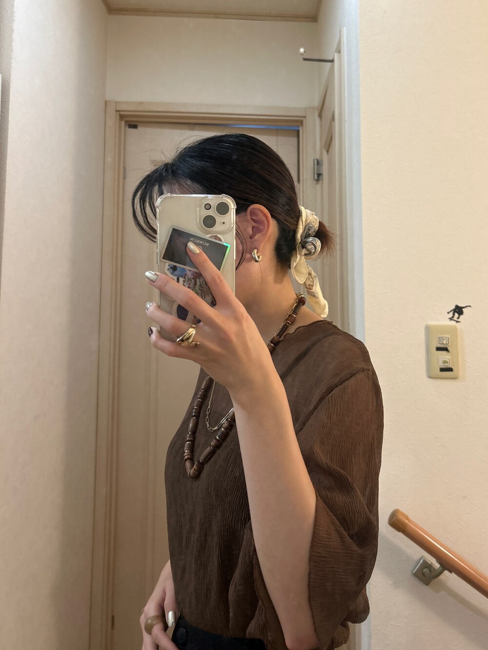 ブラック系のスカート、ブラウン系のトップスを着用したレディースの秋コーディネートの2枚目の写真