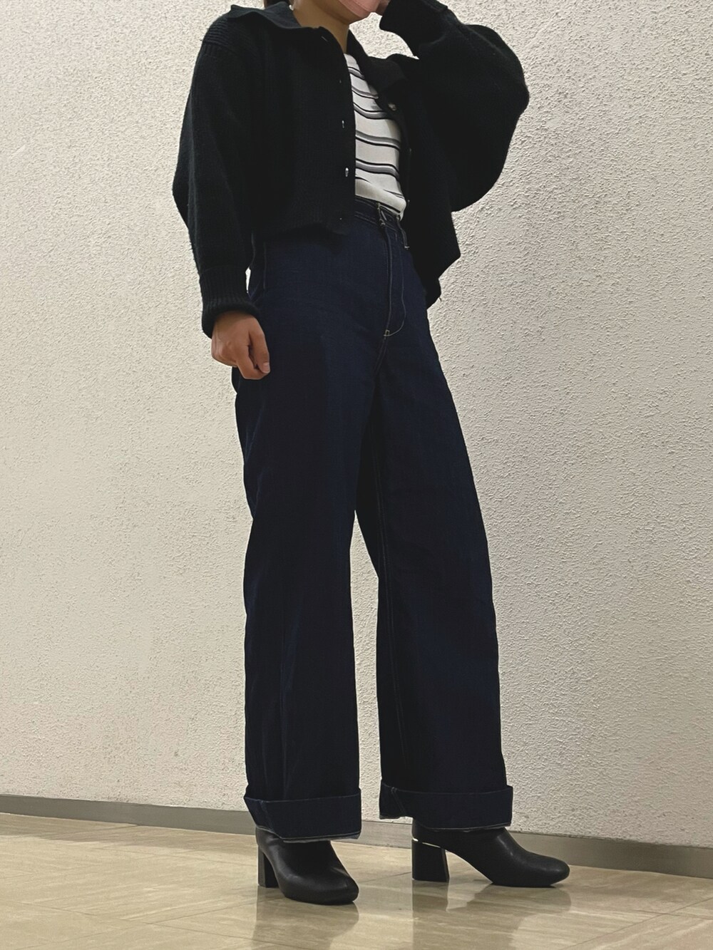 ブラック系のブーツ、ブラック系のデニムパンツ、ブラック系のカーディガン/ボレロを着用したレディースの春コーディネートの2枚目の写真