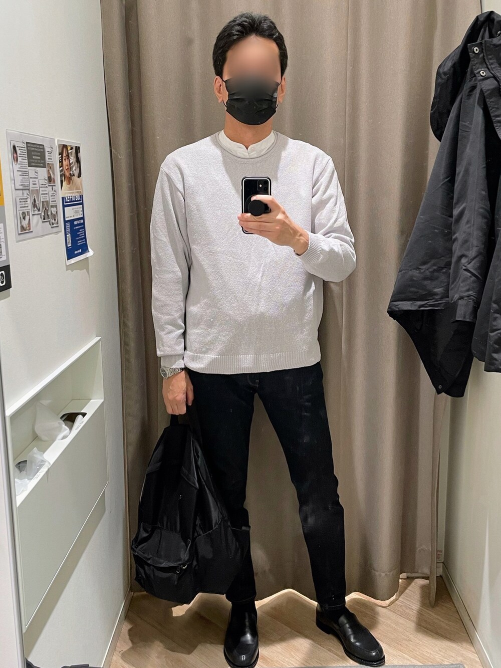 ブラック系のマウンテンパーカー、ブルー系のデニムパンツ、ブラック系のローファーを着用したメンズの冬コーディネートの2枚目の写真