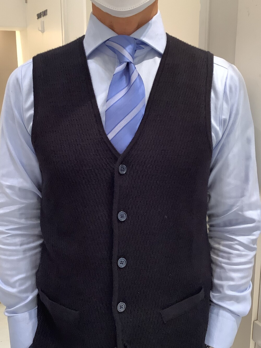 ブルー系のベストを着用したメンズの春コーディネートの2枚目の写真