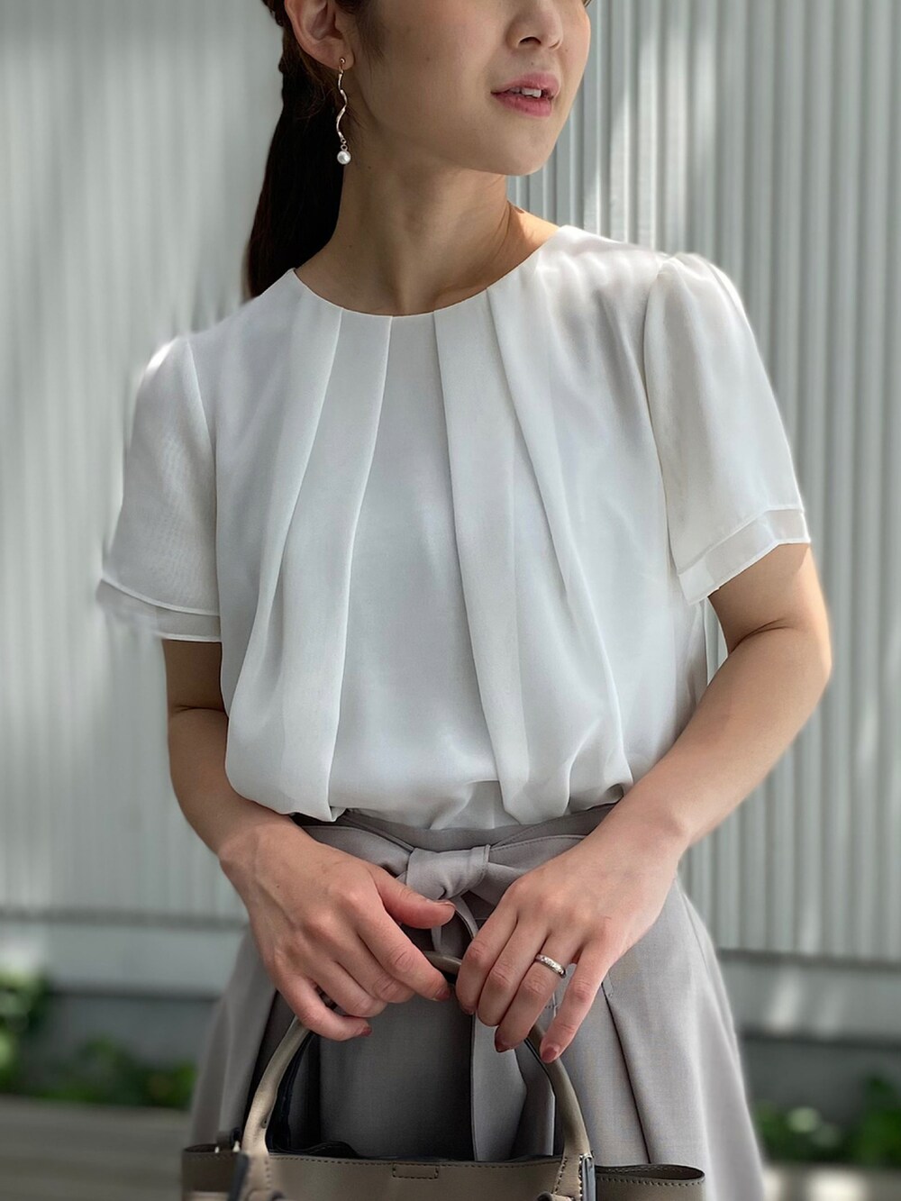 ベージュ系のサンダル、ベージュ系のハンドバッグ、ベージュ系のスカートを着用したレディースの夏コーディネートの3枚目の写真