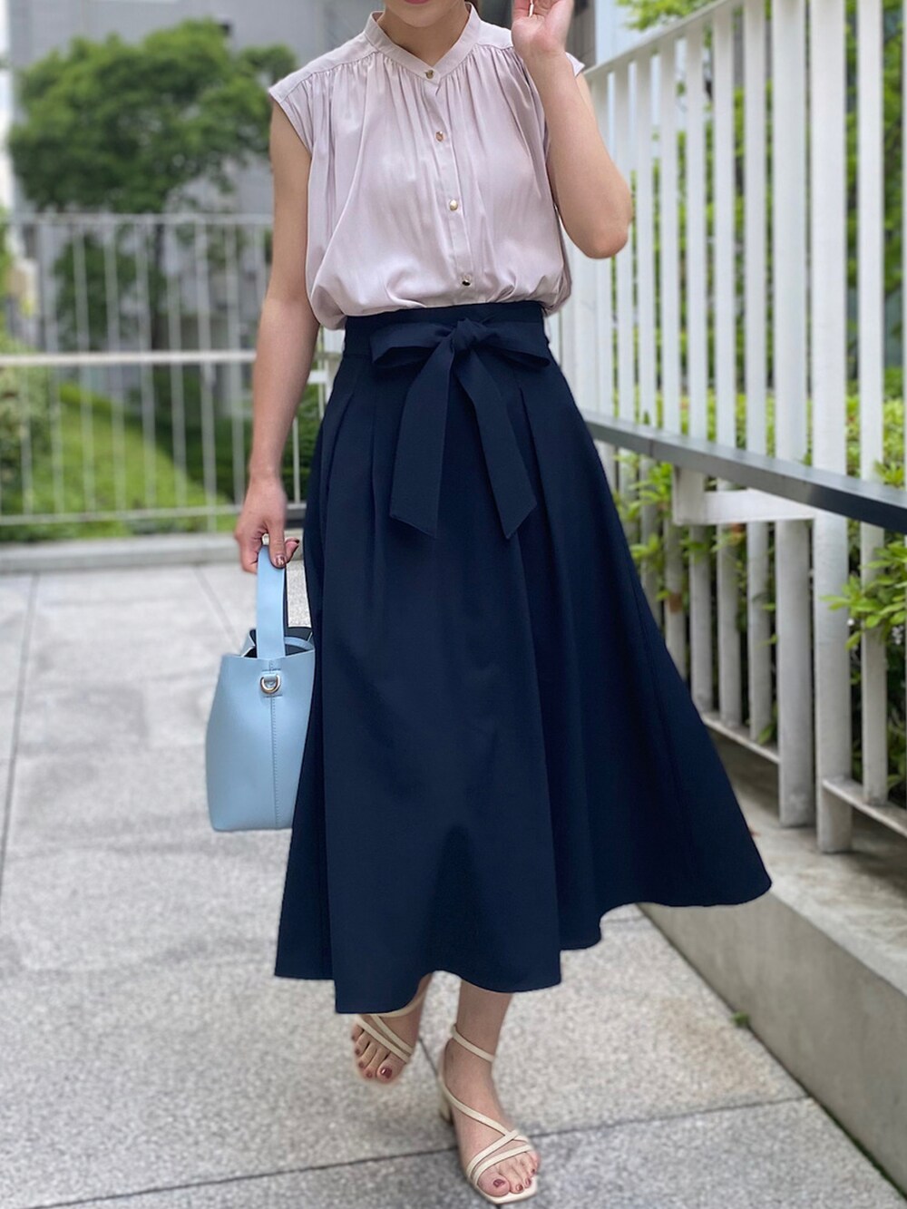 ブルー系のショルダーバッグ、ホワイト系のサンダル、ブルー系のスカートを着用したレディースの春コーディネートの2枚目の写真