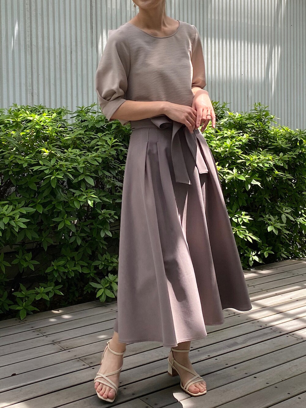 ベージュ系のシャツ/ブラウス、ベージュ系のスカート、ホワイト系のサンダルを着用したレディースの春コーディネートの2枚目の写真