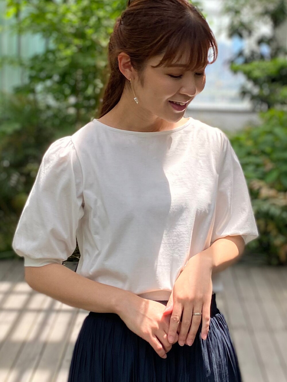 ホワイト系のTシャツ/カットソー、ブルー系のスカート、ホワイト系のサンダルを着用したレディースの春コーディネートの2枚目の写真