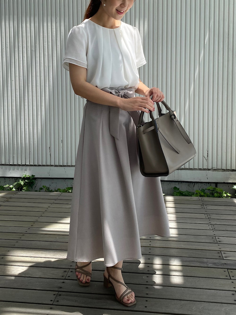 ベージュ系のサンダル、ベージュ系のハンドバッグ、ベージュ系のスカートを着用したレディースの夏コーディネートの2枚目の写真