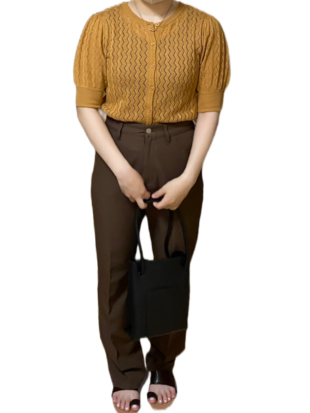 オレンジ系のトップス、ブラウン系のスラックス、ブラック系のハンドバッグを着用したレディースの夏コーディネートの5枚目の写真