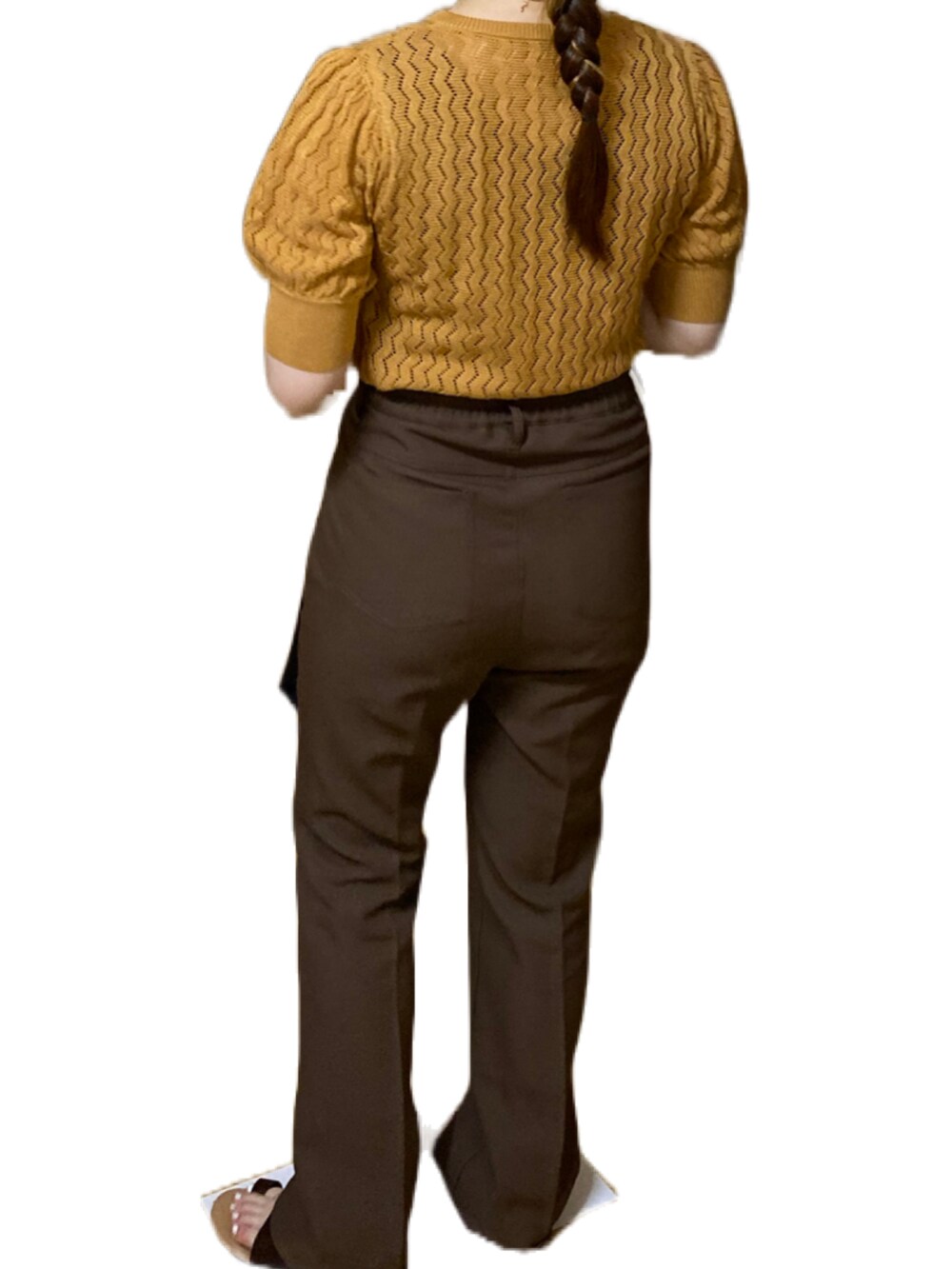 オレンジ系のトップス、ブラウン系のスラックス、ブラック系のハンドバッグを着用したレディースの夏コーディネートの4枚目の写真