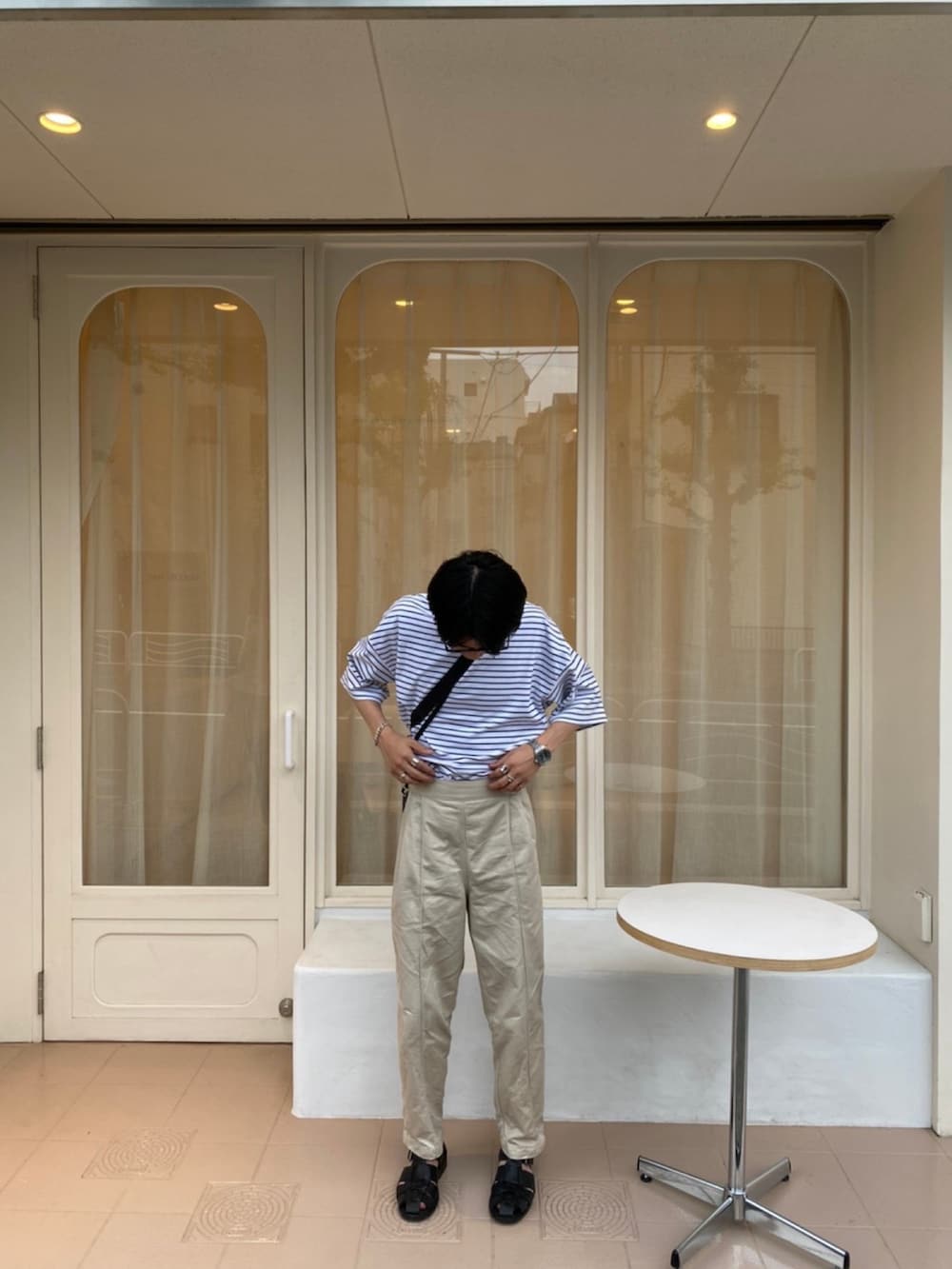 ブラック系のサンダル、ベージュ系のその他パンツ、ブルー系のTシャツ/カットソーを着用したメンズの夏コーディネートの2枚目の写真