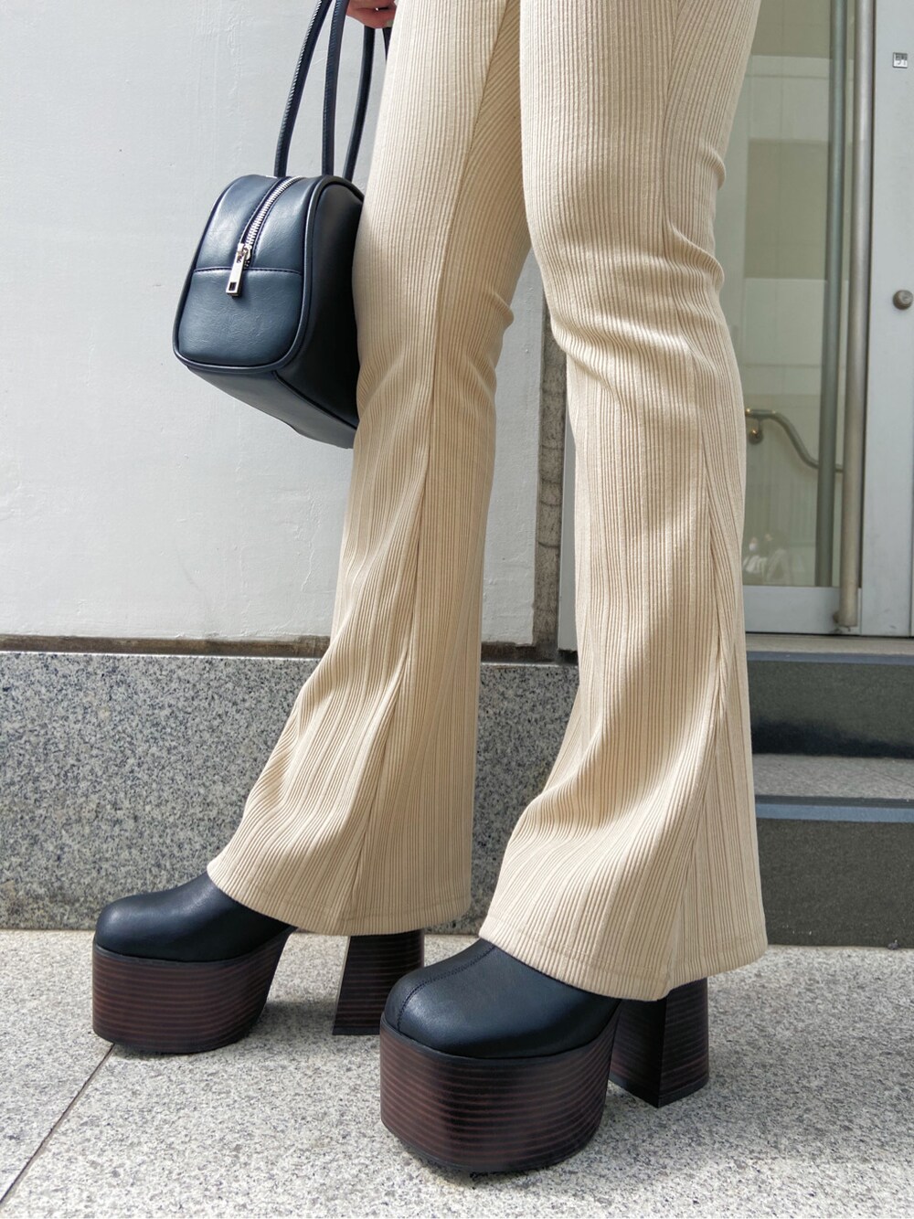 ベージュ系のその他パンツ、ブラック系のサンダル、ブラック系のハンドバッグを着用したレディースの春コーディネートの4枚目の写真