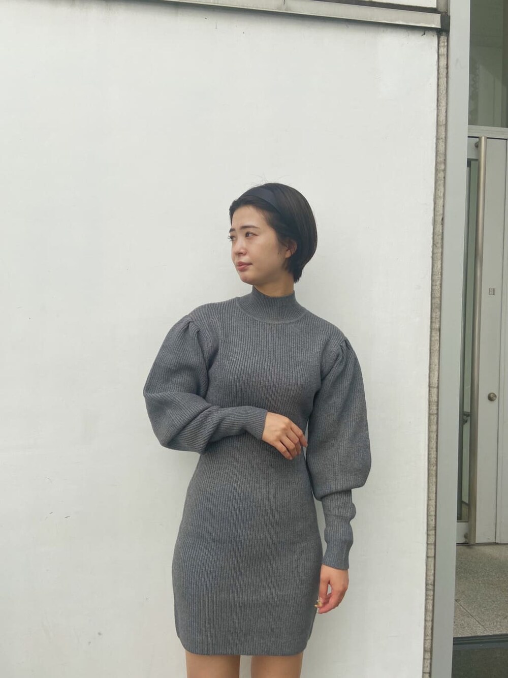 ホワイト系のブルゾン、グレー系のワンピースを着用したレディースの秋コーディネートの4枚目の写真