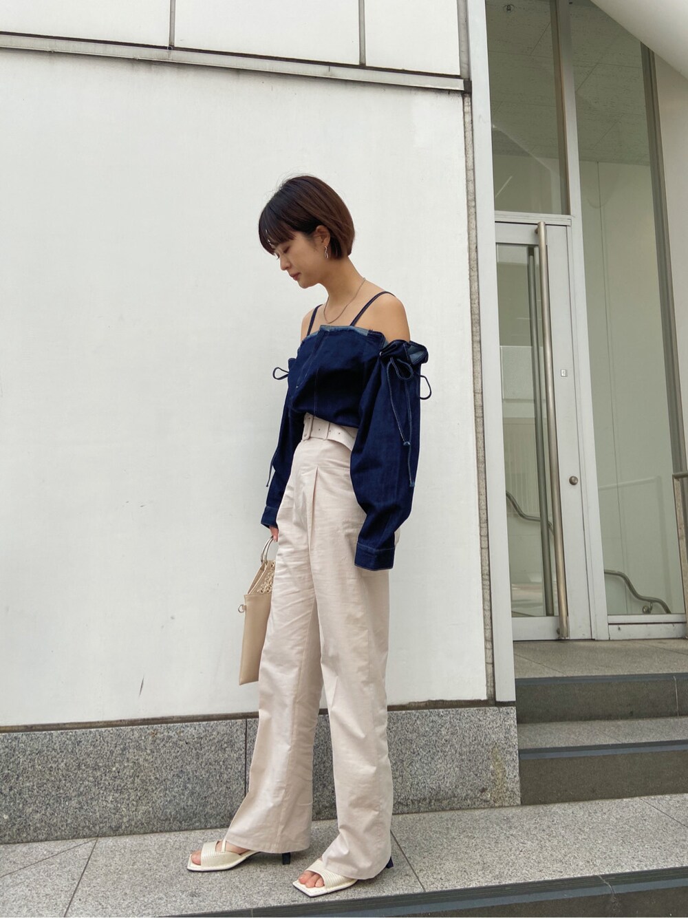 ベージュ系のハンドバッグ、ベージュ系のその他パンツ、ブルー系のシャツ/ブラウスを着用したレディースの春コーディネートの5枚目の写真