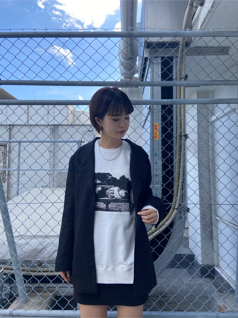 ブラック系のテーラードジャケット、ブラック系のサンダル、ホワイト系のスウェットを着用したレディースの春コーディネートの2枚目の写真