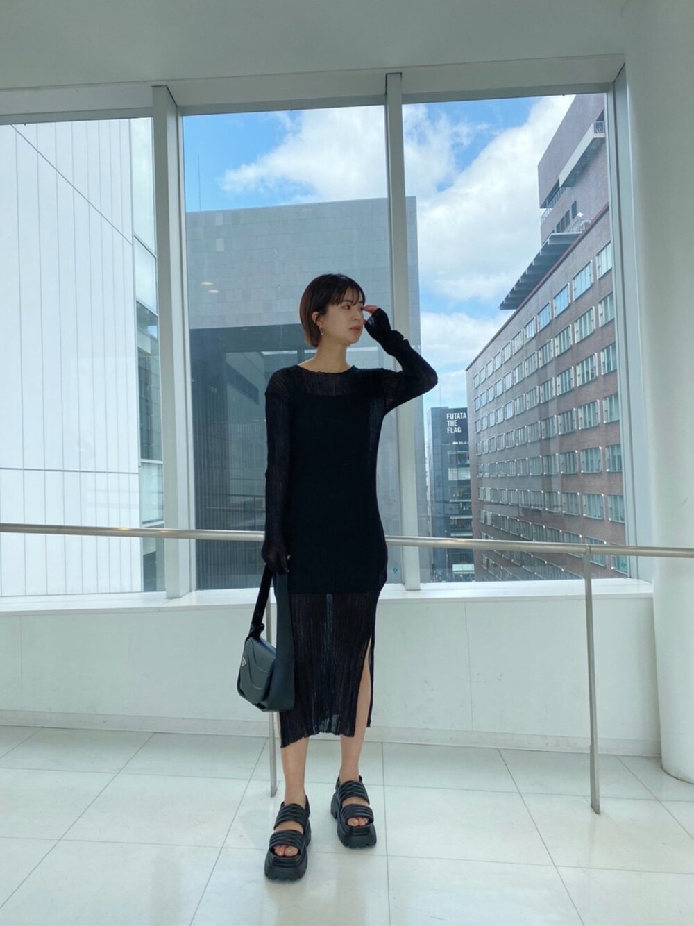 ブラック系のサンダル、ブラック系のショルダーバッグ、ブラック系のワンピースを着用したレディースの春コーディネートの3枚目の写真