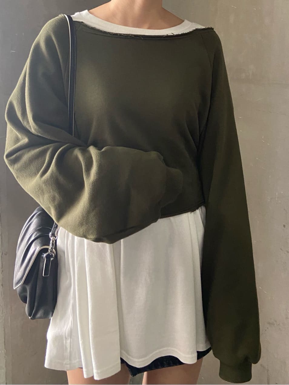 グレー系のスカート、ブラック系のショルダーバッグ、ホワイト系のTシャツ/カットソーを着用したレディースの秋コーディネートの2枚目の写真