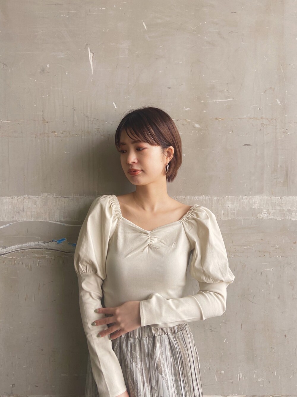 ベージュ系のTシャツ/カットソー、ホワイト系のサンダル、ベージュ系のスカートを着用したレディースの春コーディネートの4枚目の写真