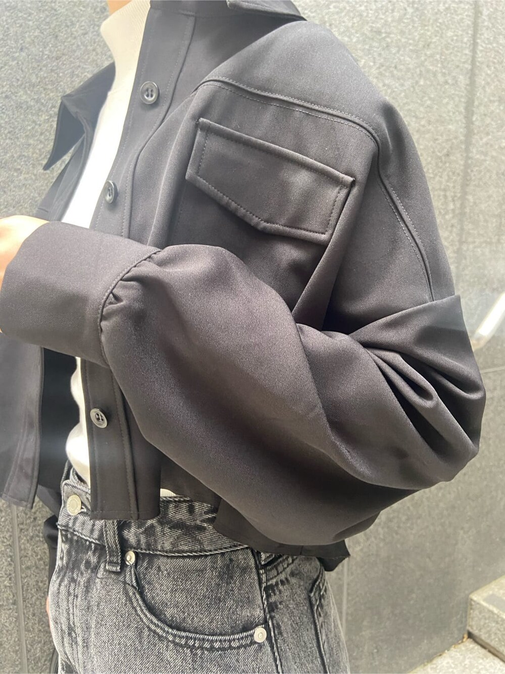 ブラック系のハンドバッグ、ブラック系のテーラードジャケット、ホワイト系のTシャツ/カットソーを着用したレディースの夏コーディネートの5枚目の写真