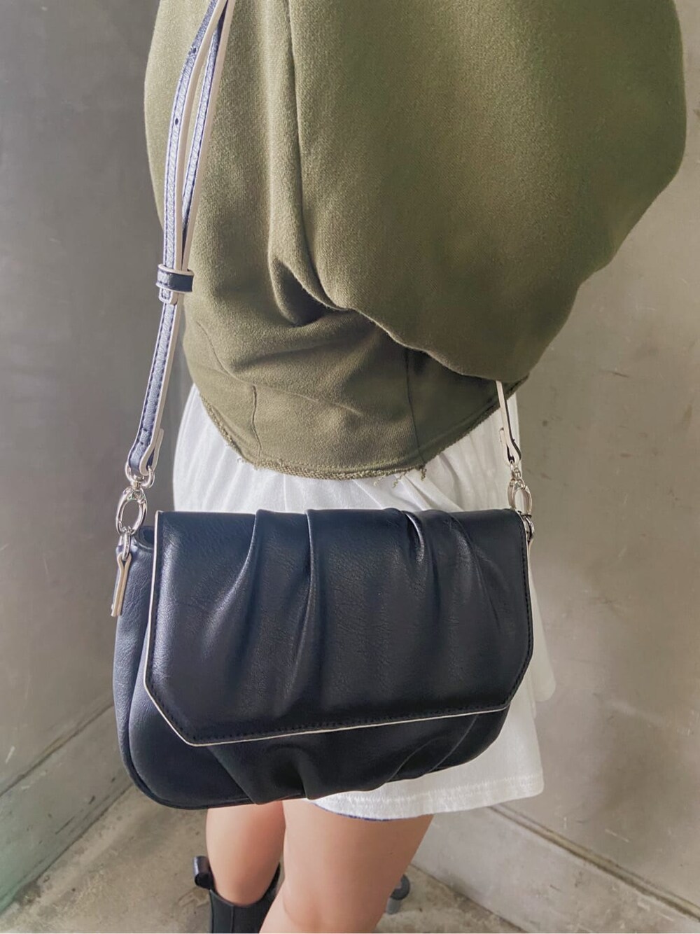 グレー系のスカート、ブラック系のショルダーバッグ、ホワイト系のTシャツ/カットソーを着用したレディースの秋コーディネートの4枚目の写真