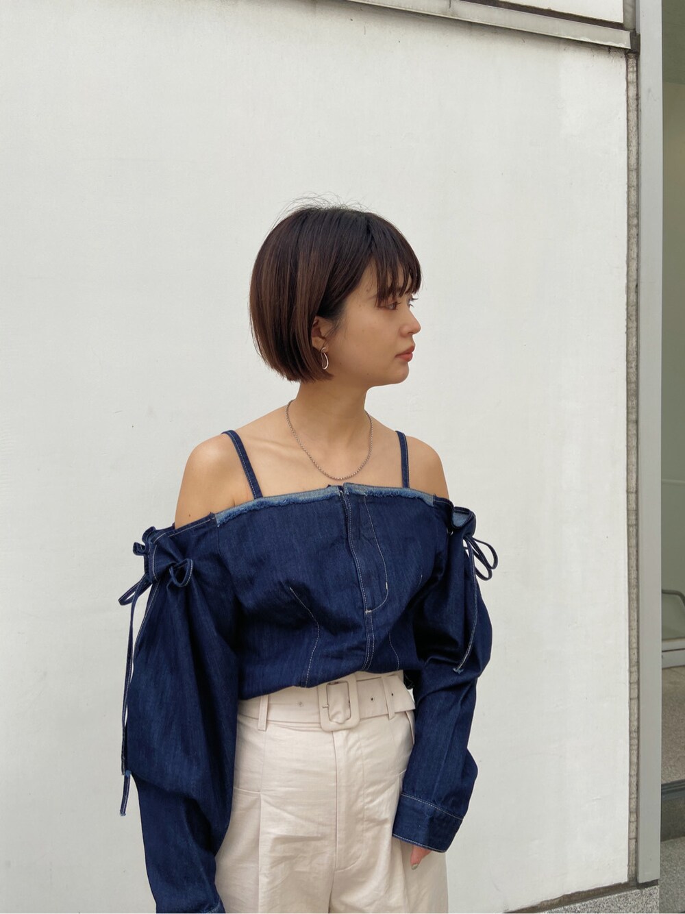 ベージュ系のハンドバッグ、ベージュ系のその他パンツ、ブルー系のシャツ/ブラウスを着用したレディースの春コーディネートの2枚目の写真